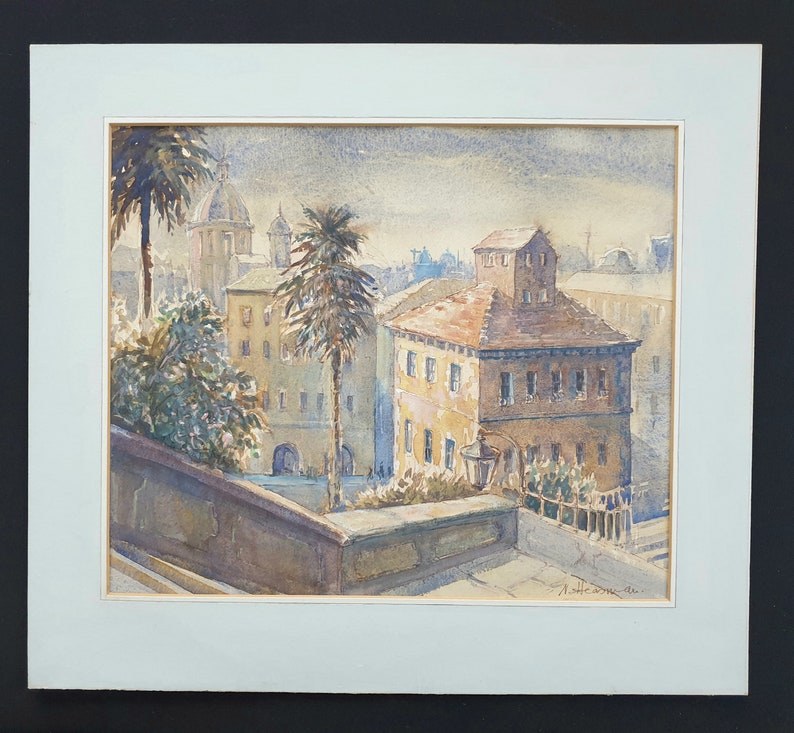 May include: Watercolor painting of a European cityscape with buildings, palm trees, and a domed structure in the background. The artwork is framed with a light blue mat and signed in the lower right corner.
