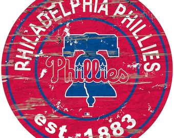 May include: A red, white, and blue distressed wood sign with the words "Philadelphia Phillies" and "Est. 1883" in a circle around the team's logo, a Liberty Bell with two stars.