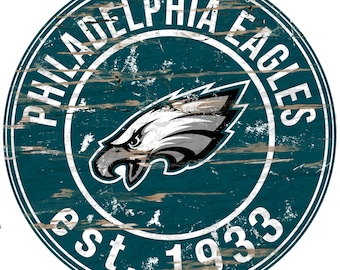 May include: A distressed, circular, teal-colored wooden sign with the words "Philadelphia Eagles est. 1933" in white lettering. A white eagle with a gray head is centered on the sign.
