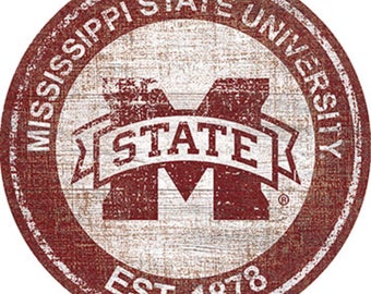 Può includere: Un cartello circolare in legno rosso e bianco con il logo della Mississippi State University. Il logo presenta una grande "M" bianca con la parola "STATE" in uno striscione bianco sopra. Il testo "Mississippi State University" è in un cerchio bianco attorno al logo. Il testo "EST. 1878" è nella parte inferiore del cartello.