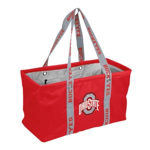 May include: A red tote bag with gray straps featuring the text "BUCKEYES". The bag has the Ohio State logo on the front. The interior is gray, and the bag has a rectangular shape.