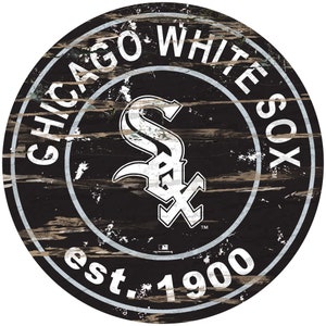 May include: A black and white circular sign with a distressed woodgrain texture. The sign features the Chicago White Sox logo, a white "S" with a white "X" inside, and the text "Chicago White Sox est. 1900".