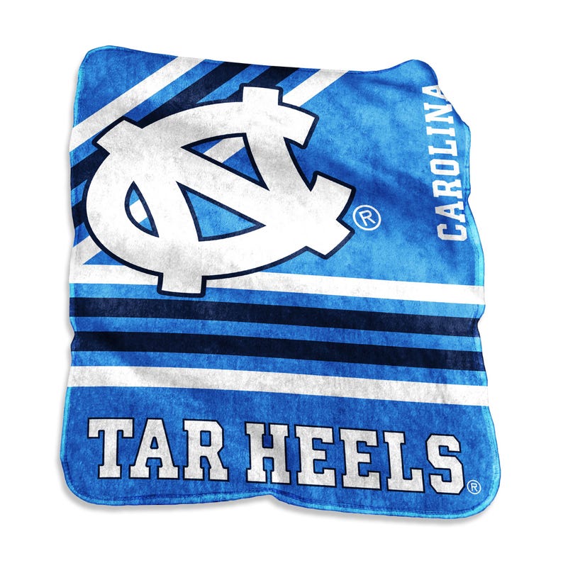 K&ouml;nnte beinhalten: Eine blau-wei&szlig;e Tar Heels-Decke. Die Decke zeigt das Logo des Teams in Wei&szlig; sowie die W&ouml;rter "CAROLINA" und "TAR HEELS" in Wei&szlig;. Der Hintergrund hat blaue und wei&szlig;e Streifen.