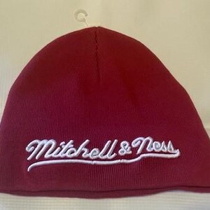 May include: A red beanie with a white embroidered logo that says "Mitchell & Ness".