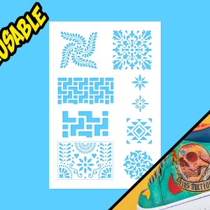 Puede incluir: Plantilla reutilizable con 10 diseños diferentes, que incluyen patrones geométricos, motivos florales y una estrella. La plantilla es blanca y se muestra sobre un fondo azul.