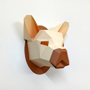 May include: A papercraft sculpture of a dog's head, with a white and brown colour scheme. The sculpture is made of folded paper and has a three-dimensional effect.