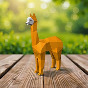 May include: A geometric, orange llama figurine with a white face and a long neck. The llama is standing on a wooden surface with a blurred green background. The figurine is made of multiple flat, angular surfaces.