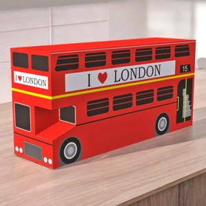 Puede incluir: Juguete de autobús de dos pisos rojo con "I ♥ LONDON" impreso en el lateral. El autobús tiene el número "15" en el lateral y una franja amarilla.