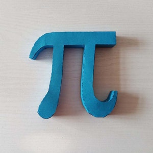 May include: A blue cardboard cutout of the mathematical symbol pi.
