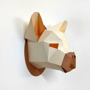 May include: A white papercraft animal head sculpture with brown accents. The sculpture is mounted on a brown circular base and appears to be a dog or wolf.