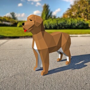May include: A brown and white origami dog with a red tongue sticking out. The dog is standing on a gray surface.
