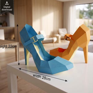 May include: A blue and an orange low-poly papercraft high-heeled shoe model. The blue shoe features a strap with a buckle. The blue shoe has a height of 22cm and a width of 28cm. The text digital download is visible in the upper left corner.