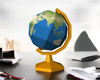 May include: A yellow and blue globe with a gold stand. The globe is a simplified, geometric representation of the Earth.