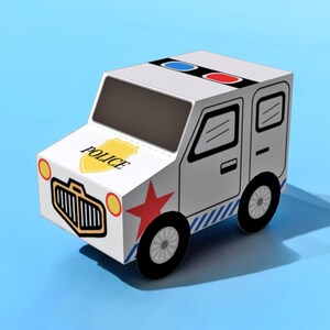 以下が含まれることがあります： 赤い星、青と赤のライト、そして側面に「POLICE」と書かれた白いおもちゃの警察車両です。