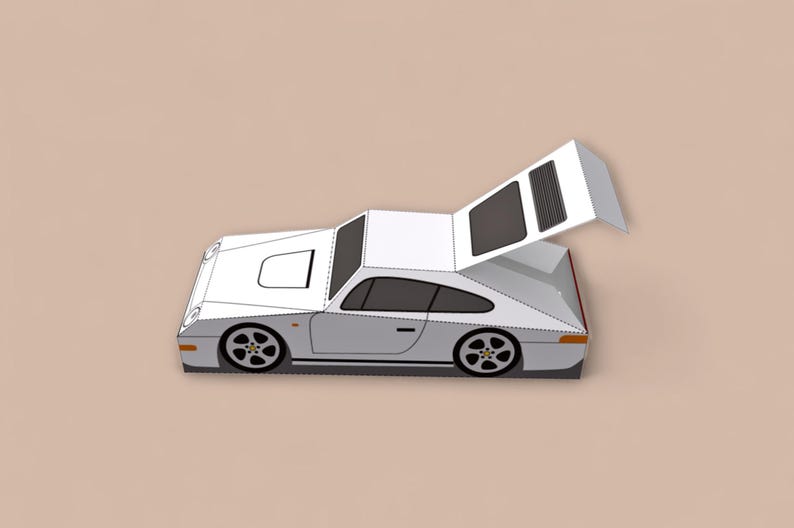 May include: A white and gray paper model of a sports car with a raised rear engine cover. The car has black wheels and windows, and is set against a neutral background. The model is a detailed representation of a classic car.