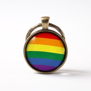 Op de afbeelding: Een sleutelhanger met een regenboog pride-vlag in een bronzen metalen frame met ring.