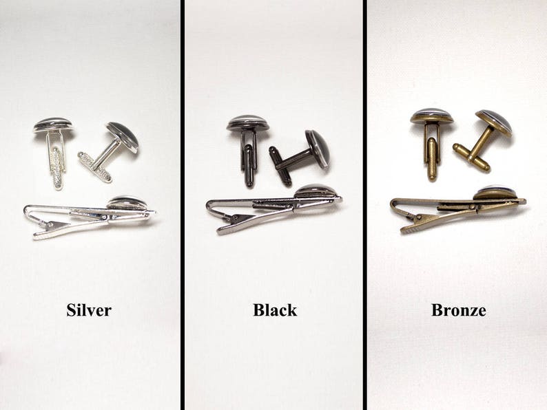 May include: Three sets of cufflinks and tie clips in silver, black, and bronze. Each set includes a pair of cufflinks and a tie clip. The cufflinks and tie clips have a circular design with a dark center. The word "Silver", "Black", and "Bronze" are below each set.