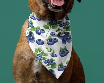 May include: A brown and black dog wearing a white bandana with a blueberry pattern. The bandana has green leaves and blue blueberries.