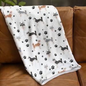 May include: White fleece throw blanket with a repeating pattern of black paw prints and colorful cartoon husky dogs.
