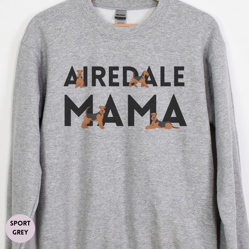 May include: A gray sweatshirt with the text "Airedale Mama" in black letters. The text is surrounded by four small illustrations of Airedale Terriers.