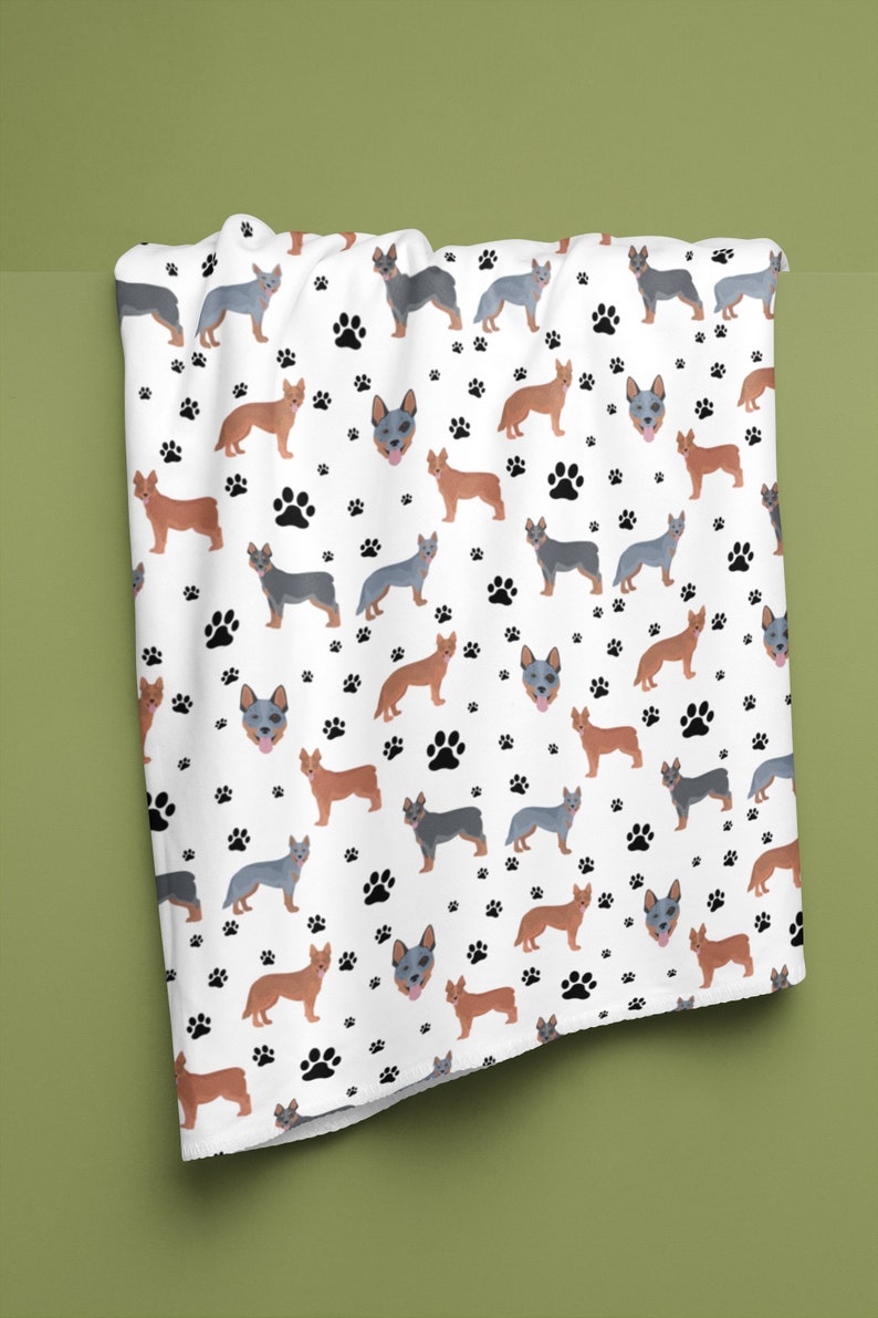 Peut inclure: Tissu blanc avec un motif r&eacute;p&eacute;t&eacute; de chiens bergers australiens bleus et bruns et d'empreintes de pattes noires.
