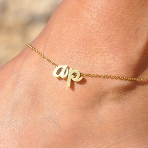 May include: A gold anklet with the word "dope" spelled out in cursive.