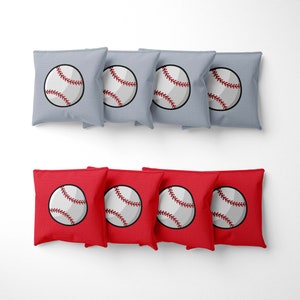 May include: Set of 10 bean bags for a game of cornhole. The bean bags are made of fabric and have a baseball design. There are 5 gray bean bags and 5 red bean bags.