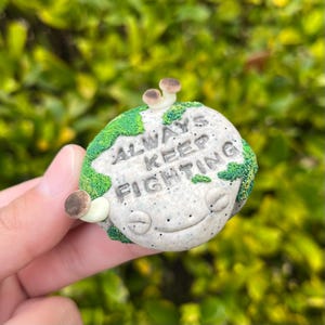 Może przedstawiać: Rustykalny drewniany szyld z napisem "Welcome to our home" w białych literach. Szyld ma postarzaną powierzchnię i prosty, zapraszający design, idealny na ganek lub do wejścia.