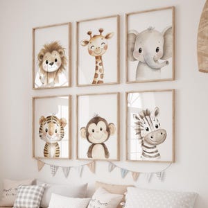 May include: A set of six framed animal prints featuring a lion, giraffe, elephant, tiger, monkey, and zebra. The prints are in a watercolour style and have a light brown background. The frames are a light wood colour.