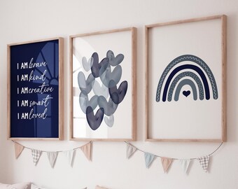 Könnte beinhalten: Drei gerahmte Drucke in einem Kinderzimmer oder Babyzimmer. Die Drucke befinden sich an einer weißen Wand mit einem Holzregal darunter. Die Drucke sind alle blau und weiß und zeigen einen Regenbogen, Herzen und die Worte "Ich bin mutig, ich bin freundlich, ich bin kreativ, ich bin klug, ich bin geliebt".