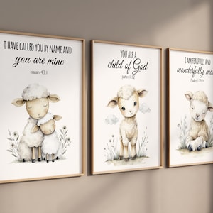 Könnte beinhalten: Drei gerahmte Aquarelldrucke mit entzückenden Lämmern. Jeder Druck hat ein anderes Zitat: "I HAVE CALLED YOU BY NAME AND you are mine", "YOU ARE A child of God" und "I AM FEARFULLY AND wonderfully made". Die Drucke sind in Holzrahmen.