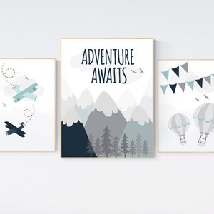 Può includere: Tre stampe incorniciate con uno schema di colori blu e grigio. La prima stampa presenta un aereo blu che vola sopra una nuvola bianca con il testo "L'avventura ti aspetta". La seconda stampa mostra un aereo blu che vola sopra una nuvola bianca. La terza stampa mostra due mongolfiere con uno schema di colori blu e grigio.