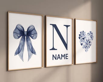 Könnte beinhalten: Drei gerahmte Drucke mit einer blauen Aquarell-Schleife, dem Buchstaben N und einem Herz aus blauen Aquarellpunkten. Der Buchstabe N wird vom Wort "NAME" gefolgt.