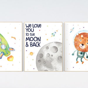 Könnte beinhalten: Drei Aquarell-Drucke mit Weltraumthema. Der erste Druck zeigt eine grüne Rakete mit einer gelben Flamme. Der zweite Druck zeigt einen grauen Mond mit dem Text "We love you to the moon & back". Der dritte Druck zeigt einen Löwen in einem Astronautenanzug.