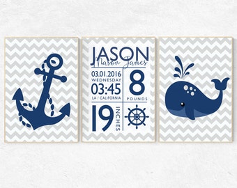 May include: Three framed prints with a nautical theme. The left print features a blue anchor on a gray chevron background. The middle print has the name "Jason Mason James" and birth details: "03.01.2016 Wednesday 03:45 LA/California 8 pounds 19 inches". The right print has a blue whale on a gray chevron background.