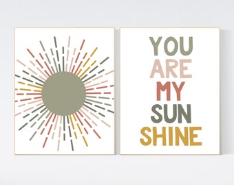 May include: Two framed prints with a white background. The left print features a stylized sun with rays in shades of green, pink, red, and yellow. The right print features the text "YOU ARE MY SUNSHINE" in a colorful block font.