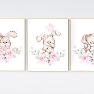 May include: Three watercolor illustrations of bunnies with pink flowers. Each bunny is brown with a pink nose and pink flowers in their fur. The background is white.