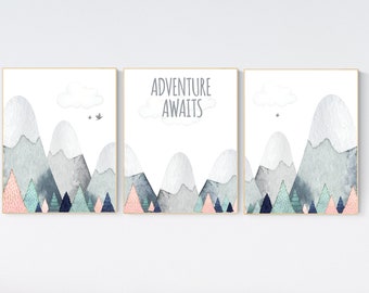 Op de afbeelding: Een set van drie aquarelprints met een bergketen met een wolk en vogels, en de tekst "Avontuur wacht".