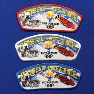 Puede incluir: Tres parches bordados con el texto "Great Salt Lake Council" y los anillos olímpicos. Los parches son rojo, blanco y azul.
