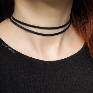 May include: A black choker necklace with two layers of thin fabric.