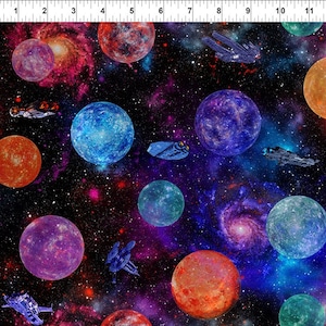 May include: A colorful space-themed fabric with planets, stars, and spaceships. The fabric features a dark blue background with bright colors like red, orange, blue, green, and purple. The planets are various sizes and shapes, and the spaceships are flying through the galaxy.