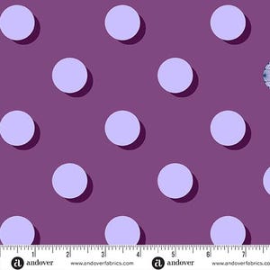 May include: A patterned fabric featuring large, pale purple circles set against a deep purple backdrop. Each circle has a shadow, giving a 3D effect. A ruler is visible at the bottom of the fabric. The fabric is from Andover.