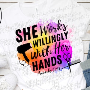 Könnte beinhalten: Ein weißes T-Shirt mit einem Aquarellhintergrund, auf dem ein Föhn und eine Schere zu sehen sind. Der Text auf dem Shirt lautet "She Works Willingly With Her Hands Proverbs 31:13".