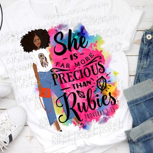 May include: A white sublimation t-shirt with a watercolor design featuring a woman with a crown of flowers and the text "She is far more precious than rubies Proverbs 3:15".