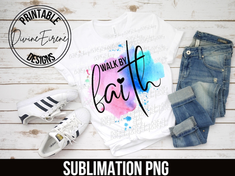 May include: A white t-shirt with a watercolor design of pink, blue, and purple colors. The text "Walk by Faith" is written in black lettering over the watercolor design. A small heart is included in the text.