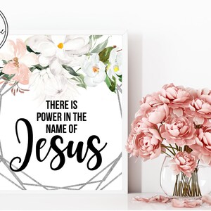 May include: A white printable art print with a floral design and the text "There is power in the name of Jesus".
