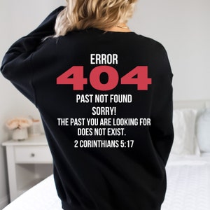 Op de afbeelding: Zwart sweatshirt met een rode "ERROR 404" afbeelding en de tekst "PAST NOT FOUND SORRY! THE PAST YOU ARE LOOKING FOR DOES NOT EXIST. 2 CORINTHIANS 5:17"