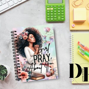 May include: A spiral bound journal with a colorful cover featuring a woman with dark hair and a floral design. The text "Girl Pray About It" is printed on the cover.