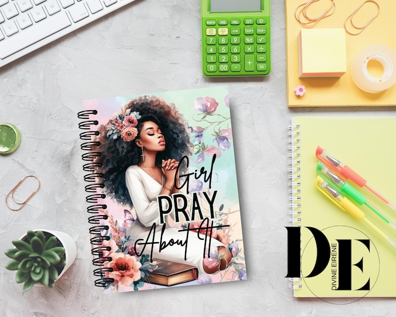 May include: A spiral bound journal with a colorful cover featuring a woman with dark hair and a floral design. The text "Girl Pray About It" is printed on the cover.