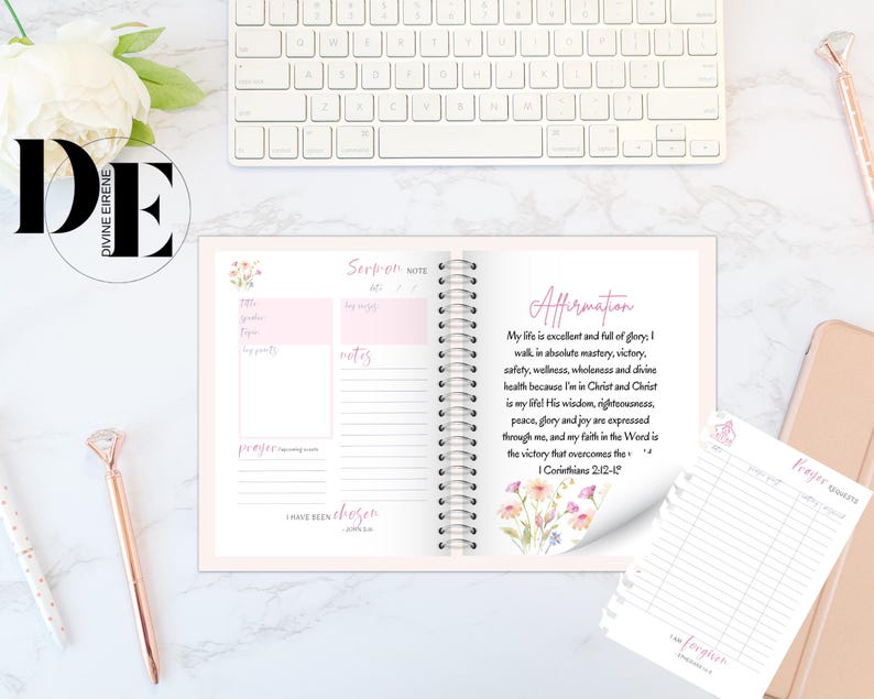 May include: A pink and white journal with a floral design on the cover. The journal has a spiral binding and includes sections for scripture, notes, prayer, and affirmations. The affirmation section includes the text "My life is excellent and full of glory: I walk, in absolute mastery, victory, safety, wellness, wholeness and divine health because I'm in Christ and Christ is my life! His wisdom, righteousness, peace, glory and joy are expressed through me, and my faith in the Word is the victory that overcomes the... 1 Corinthians 2:12-14".